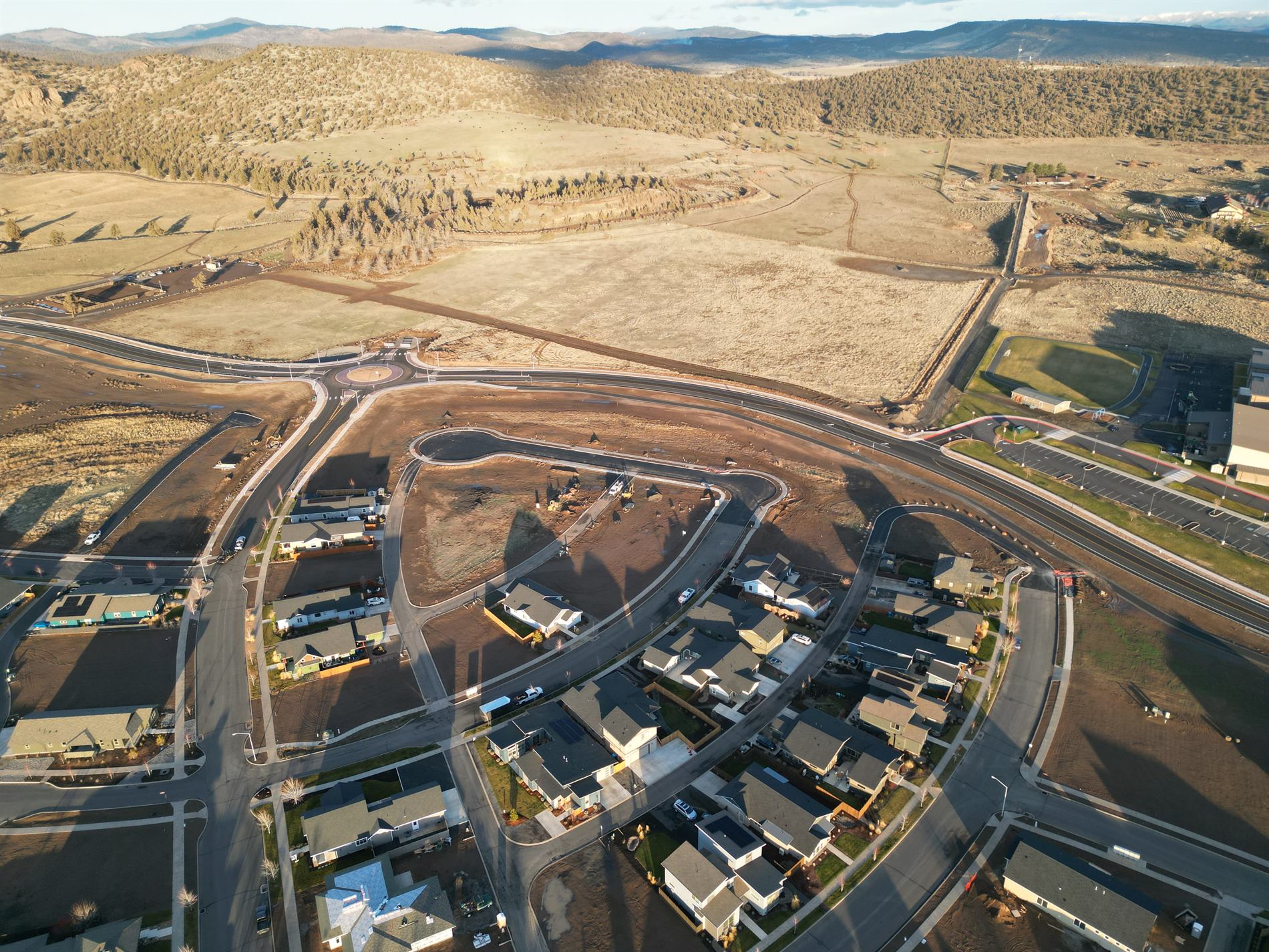 Golden-hour aerial view of the Barnes Butte area, roads, homes, and surrounding hills